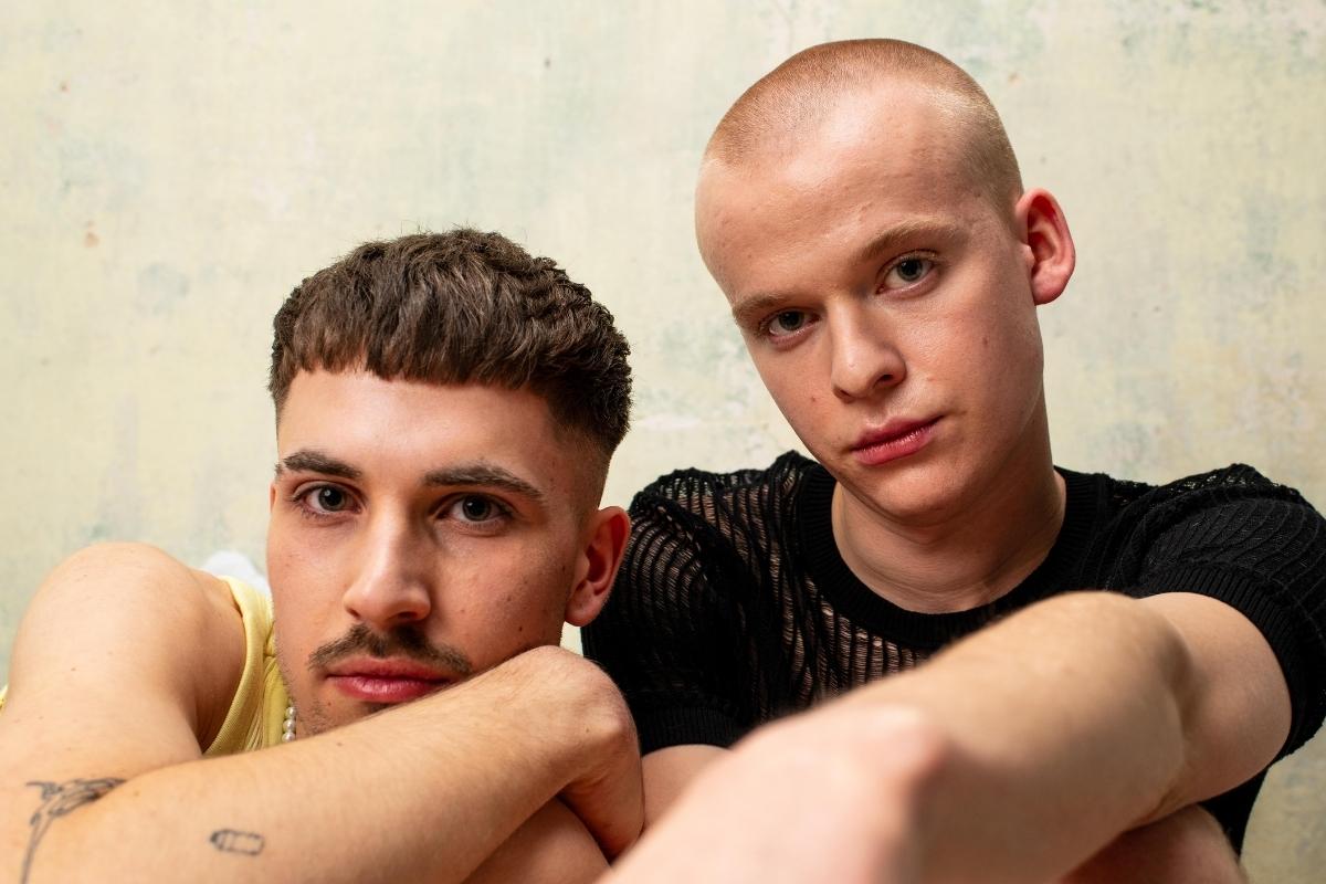 Zwei junge Männer sitzen nebeneinander