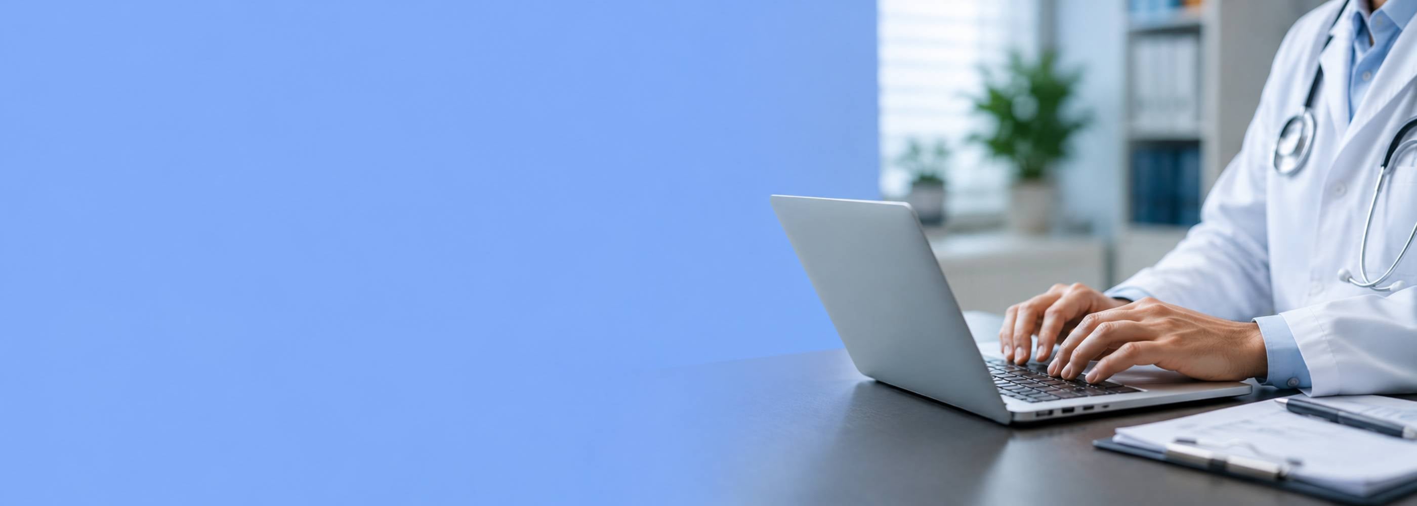 Ein Arzt in weißem Kittel mit Stethoskop tippt auf einem Laptop, neben ihm liegen medizinische Unterlagen auf einem Klemmbrett. Das Bild symbolisiert die sorgfältige, diskrete ärztliche Prüfung des Online-Fragebogens zur Behandlung von Erektionsstörungen.
